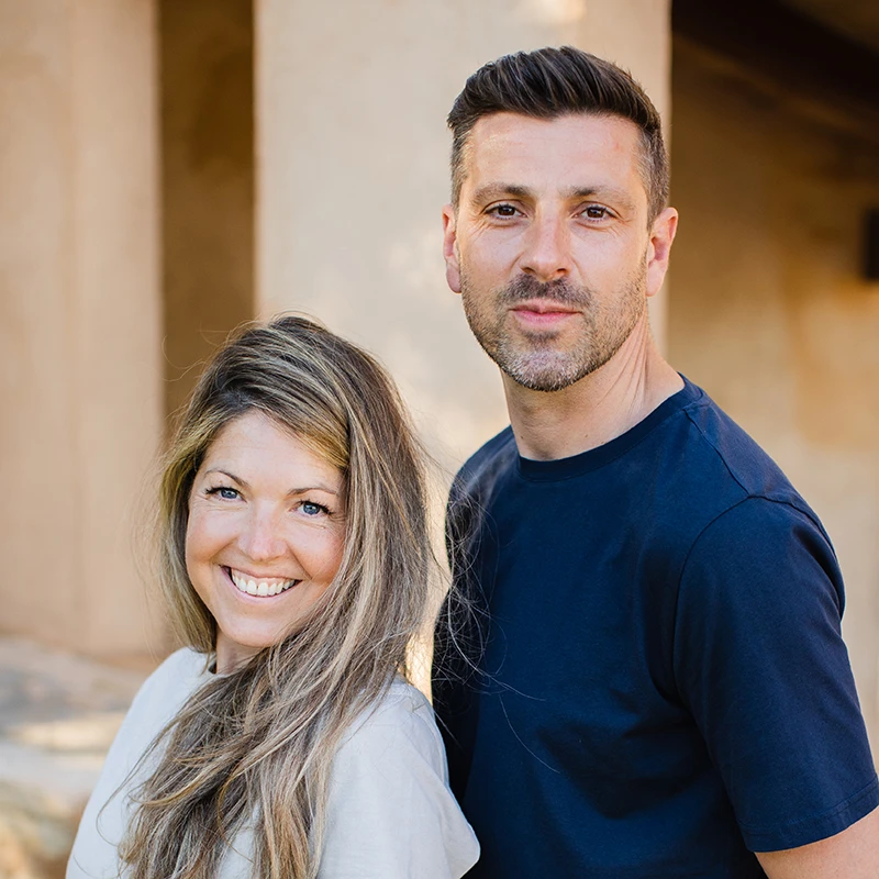 Two people sitting on a wall talking