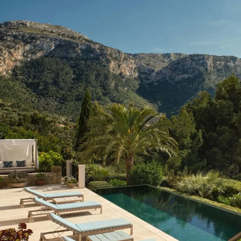 Swimming pool and blue sun loungers with a mountain view