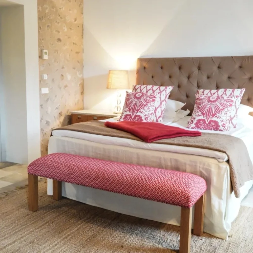 Picture of a bed with red and white cushions 